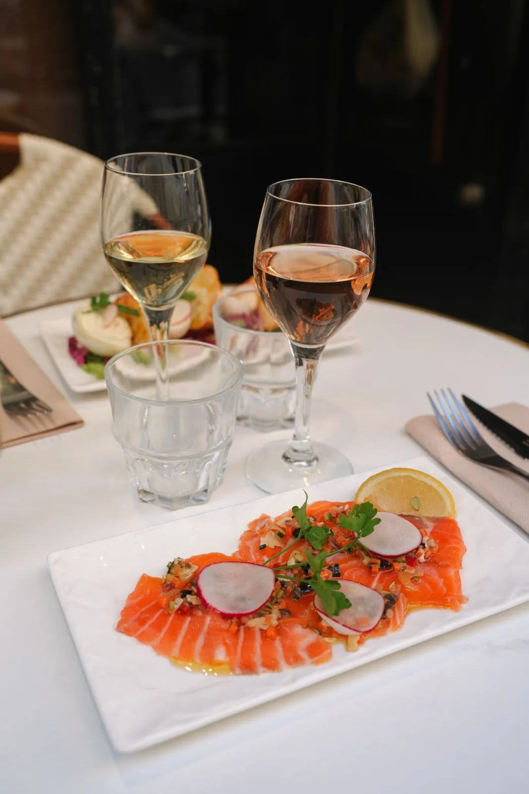 Carpaccio de saumon dressé sur nappe blanche